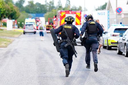 Einsatzkräfte auf dem Weg zum Tatort bei Aalborg.