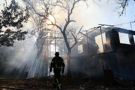 Ein Feuerwehrmann ist im Einsatz, nachdem eine russische Bombe ein Haus im ukrainischen Saporischschja getroffen hat.