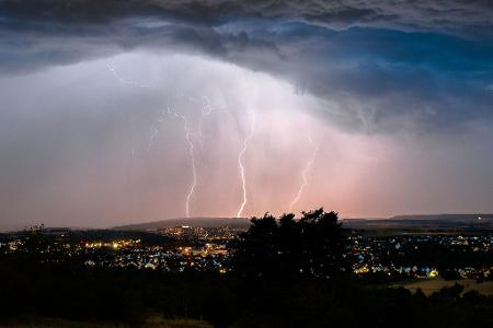 Blitze zucken bei einem Sommergewitter in der Nacht über Mössingen in Baden-Württemberg.