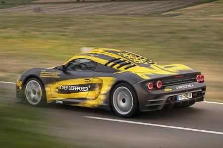 Ruf 8Zylinder Prototyp auf Landstraße, getarnter Sportwagen mit gelb-schwarzer Folierung, in Fahrt.
