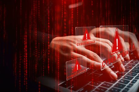 Mensch am Laptop initiiert Cyberattacke