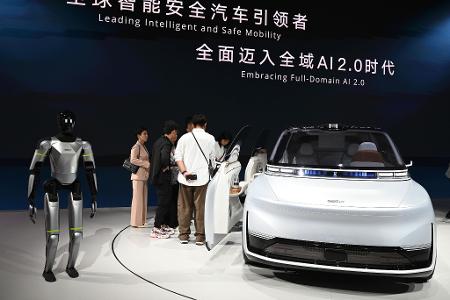 Hier präsentiert Geely ein Auto samt humanoidem Roboter auf einer Automesse in Peking. Nun wagt die Firma den Sprung nach Spanien, um dort Autos zu bauen. 
