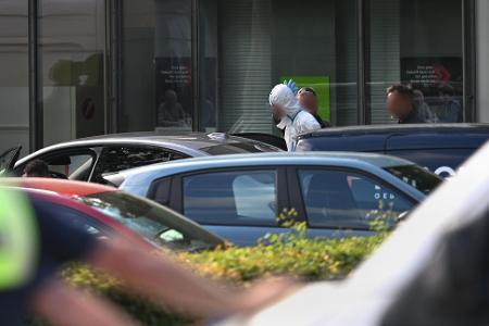 Polizisten führten am Abend einen Mann in einem weißen Anzug aus dem Gebäude, wenig später wurde eine Festnahme vermeldet.
