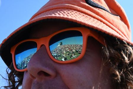 In der Sonnenbrille eines Besuchers spiegelt sich bei dem Musikfestival 