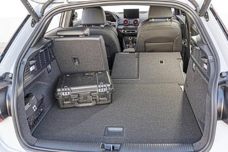 Audi SQ2 TSFI quattro S-tronic, Blick in den Kofferraum mit umgeklappter Rückbank und Transportkoffer.