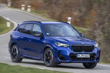 BMW X1 M35i xDrive in blauer Lackierung auf kurviger Landstraße, fahrend, Front- und Seitenansicht.