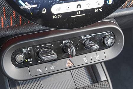 Detailaufnahme der Mittelkonsole und Bedienelemente eines Mini JCW Countryman 4all, inklusive Start-Stopp-Knopf und Fahrmodi-Schalter.