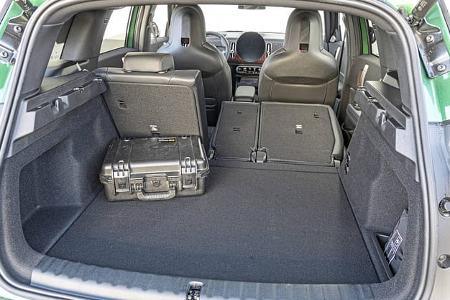 Kofferraumansicht eines Mini JCW Countryman 4all mit umgeklappter Rückbank und Transportkoffer.
