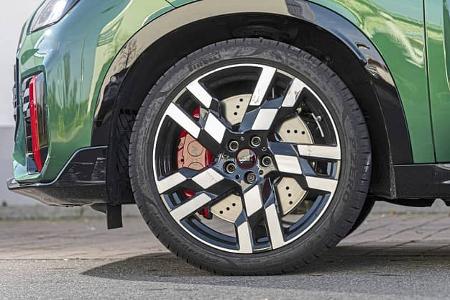 Detailaufnahme des Vorderrads eines Mini JCW Countryman 4all, Fokus auf Felge und Bremse.