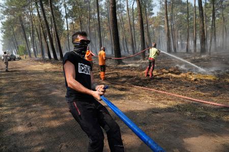 Bei ihren Löscharbeiten wird die Feuerwehr in Frankreich von Anwohnern, Landwirten und weiteren Freiwilligen unterstützt.