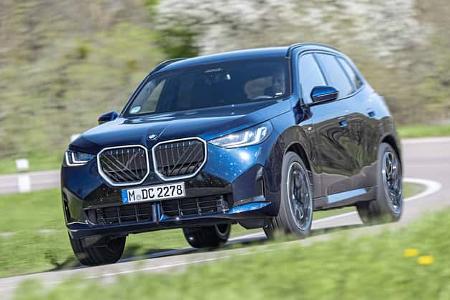 BMW X3 20 xDrive in blauer Lackierung auf Landstraße, Frontansicht, fahrend, mit Fahrer im Fahrzeug.