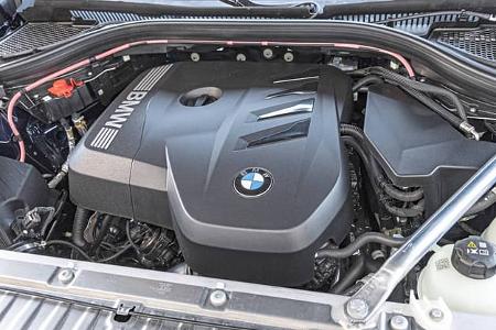 Detailaufnahme des Motorraums eines BMW X3 20 xDrive, Modelljahr 2024, mit sichtbarer Motorabdeckung und technischen Komponenten.