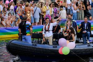 Der niederländische Ministerpräsident Rob Jetten steht auf einem Boot und winkt während der Canal Parade in Amsterdam.