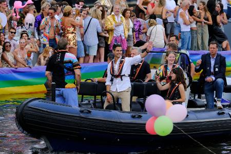 Der niederländische Ministerpräsident Rob Jetten steht auf einem Boot und winkt während der Canal Parade in Amsterdam.