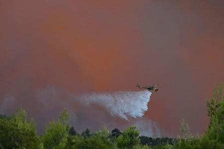 Es dürfte der einzige Hubschrauber gewesen sein, der es wagte: Starke Winde machten die Löscharbeiten aus der Luft unmöglich.