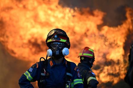 Ein Feuerwehrmann steht vor den lodernden Flammen nordwestlich von Athen.