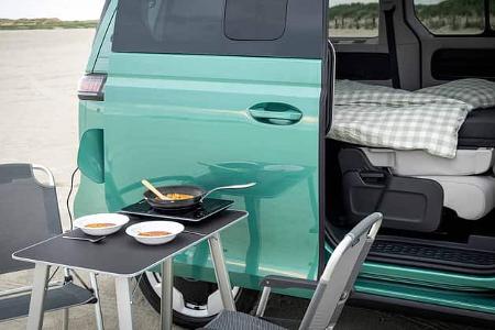 Campingtisch vor Fahrzeug, Campingszene, Detail Abendessen, mobiler Induktionskocher auf Campingtisch