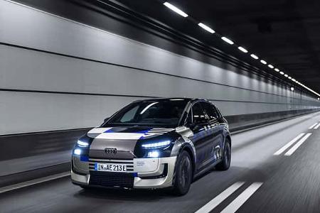 Audi A2 e-tron Erlkönig fährt in einem beleuchteten Tunnel. Das Fahrzeug trägt eine Tarnlackierung und ist als Prototyp erkennbar.