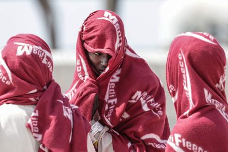 Auf See gerettete Migranten warten im Port de Commerce in Nordfrankreich.