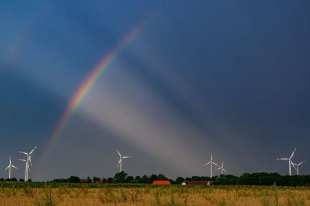 Zusammenspiel von Farbe und Licht: Regenbogen vor Gewitterwolken