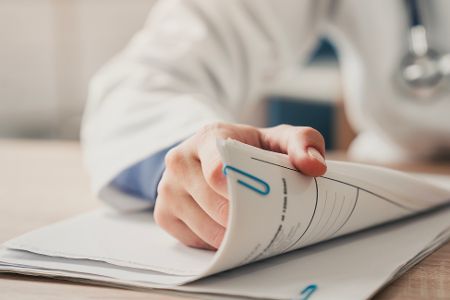 Arzt hält medizinische Akte in der Hand