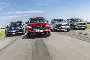 Vier aktuelle SUV-Modelle (Citroën C5 Aircross Hybrid, Mazda CX-5, Kia Sportage, Ford Kuga) fahren nebeneinander auf einer Landstraße. Die Fahrzeuge sind frontal und dynamisch im Verband aufgenommen, alle Modelle sind klar erkennbar.