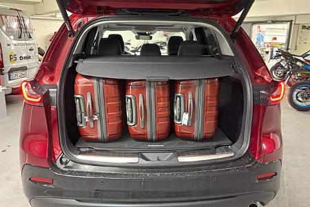 Mazda CX-5 Kofferraum mit vier Koffern, geöffnet, in einer Tiefgarage.