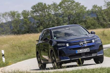 Citroen C5 Aircross Hybrid fährt auf einer Landstraße durch eine grüne Landschaft.