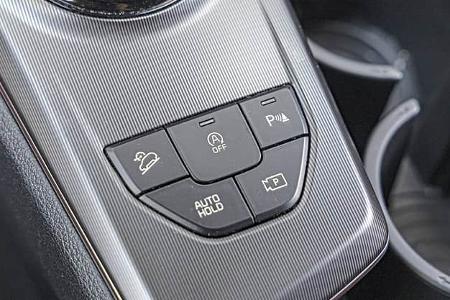 Detailaufnahme der Mittelkonsole eines Kia Sportage 1,6 T-GDI mit Bedientasten für Fahrassistenzsysteme.