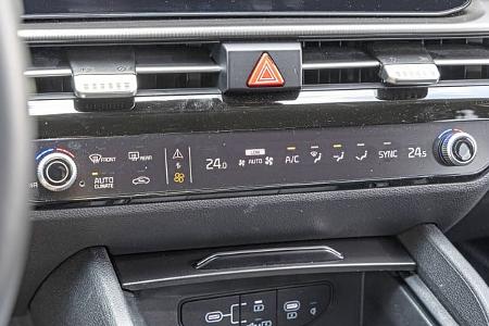 Detailaufnahme der Mittelkonsole und Klimabedieneinheit eines Kia Sportage 1,6 T-GDI (Modelljahr 2024). Sichtbar sind die Bedienelemente für die Klimaanlage, Lüftung und Warnblinkanlage.
