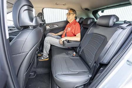 Innenaufnahme eines Kia Sportage 1,6 T-GDI mit einer Person auf der Rückbank.