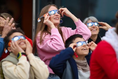 Menschen schauen mit speziellen Brillen in den Himmel