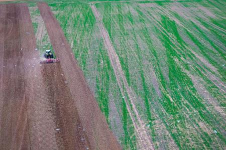 Ein Traktor zieht bei Rosenhagen eine Egge über ein abgeerntetes Getreidefeld und bereitet den Acker auf die Aussaat vor (Aufnahme mit Drohne).