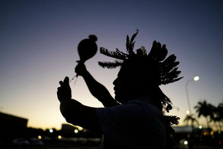 Ein indigener Mann führt während einer Demonstration ein Ritual durch.