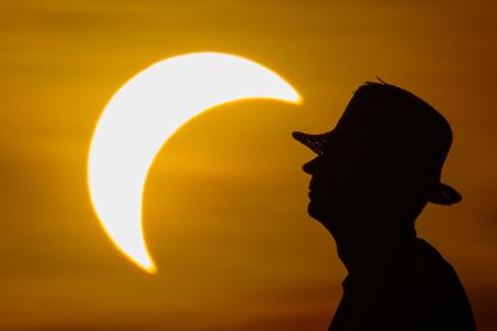 Ein Mann betrachtet die partielle Sonnenfinsternis im östlichen Brandenburg.