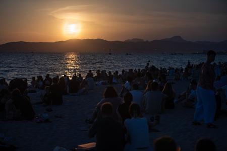 Menschen sitzen am Strand von Palma und warten auf die totale Sonnenfinsternis.