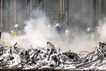 Feuerwehrleute löschen einen Böschungsbrand zwischen Sauerlach und Hofolding in der Nähe der Autobahn A8.