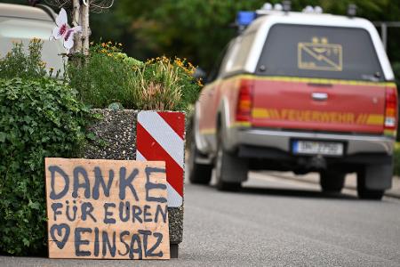 Ein Fahrzeug der Feuerwehr fährt an einem Schild mit der Aufschrift 