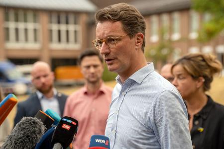 Nordrhein-Westfalens Ministerpräsident Hendrik Wüst (CDU) sprich während seines Besuchs bei Einsatzkräften mit Medienvertretern. 