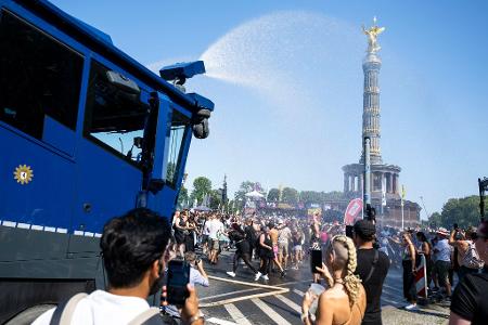 Ein Wasserwerfer der Polizei verschafft den Ravern etwas Abkühlung. 