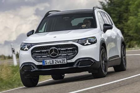 Mercedes GLB 250+ auf Landstraße, Frontansicht, weißes SUV, dynamische Kurvenfahrt, Tageslicht.