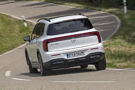 Mercedes GLB 250+ auf kurviger Landstraße, Heckansicht, weißes SUV, Fahrdynamik, Sommer, Tageslicht.