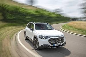 Mercedes GLB 250+ fährt auf einer kurvigen Landstraße. Das weiße SUV ist in Bewegung, die Umgebung ist verwischt.