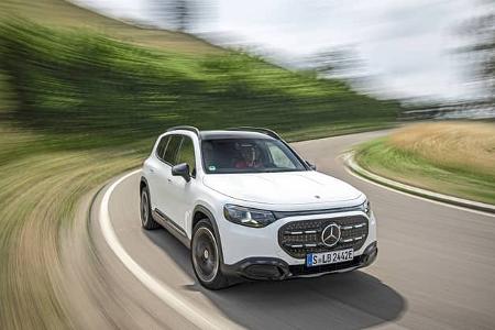 Mercedes GLB 250+ fährt auf einer kurvigen Landstraße. Das weiße SUV ist in Bewegung, die Umgebung ist verwischt.
