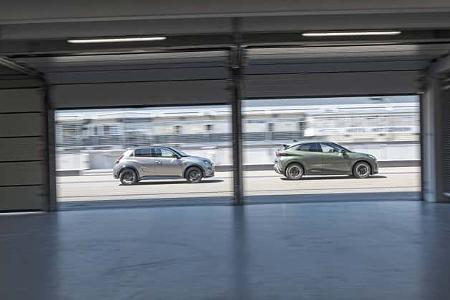 Zwei Fahrzeuge, Cupra Raval und Alpine A290GTS, fahren nebeneinander an der Boxengasse des Hockenheimrings vorbei. Die Aufnahme erfolgt aus einer Box heraus und zeigt beide Fahrzeuge in Seitenansicht.