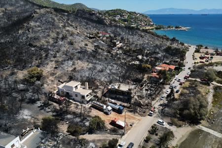 Nach dem Feuer auf der griechischen Insel Salamis ist ein Berghang verbrannt und voll Asche.