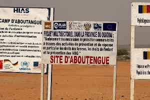 Auf dem Gelände eines Lagers für Flüchtlinge aus dem Sudan im Osten des Tschads stehen die Logos von Hilfsorganisationen, die dort im Einsatz sind. (Archivbild)