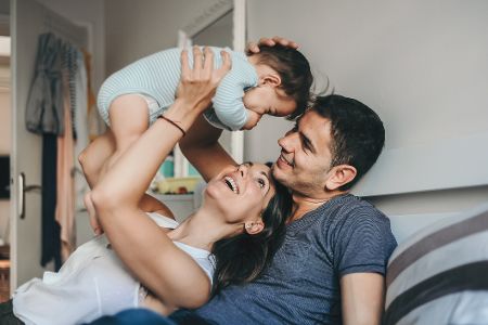 Vater, Mutter und Baby glücklich auf dem Sofa
