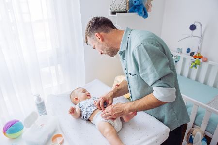 Vater wickelt sein Baby