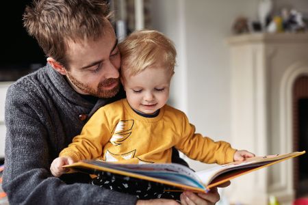 Vater liest mit seinem Kleinkind in einem Buch